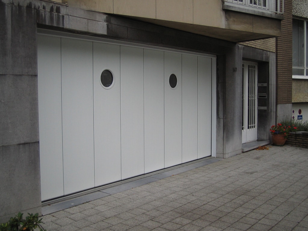 Porte de garage sectionnelle à refoulement latéral blanche avec deux hublots ronds wizeo fermetures réalisations