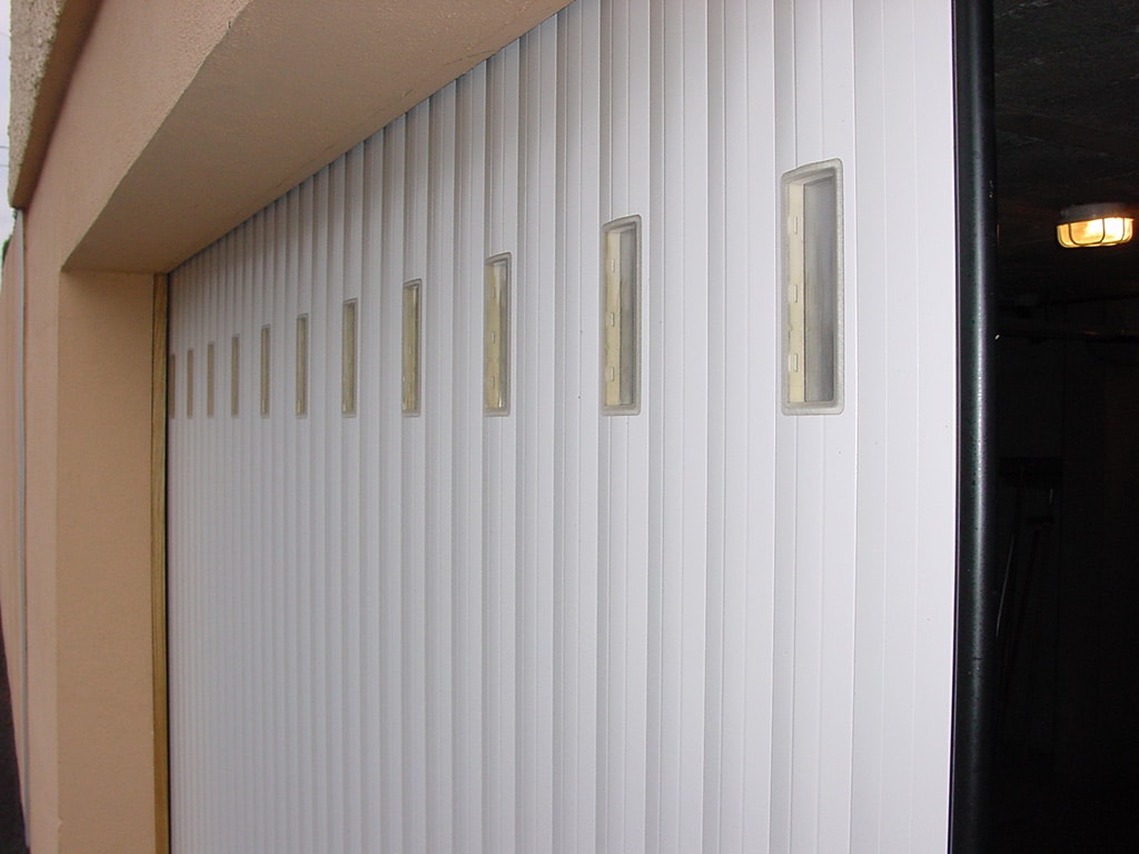 Porte de garage à lames blanche à refoulement latéral avec hublots rectangles, wizeo fermetures réalisations