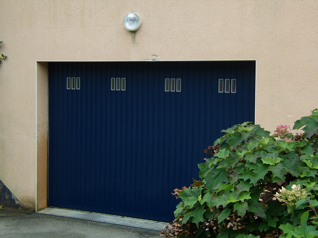 Porte de garage à lames à refoulement latéral couleur noir avec hublots, wizeo fermetures réalisations
